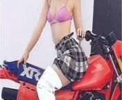 Dove Cameron in a pink bra straddling a motorcycle from dove cameron por