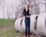Blonde pisses on field behind concrete rings 25641 from concrete touching
