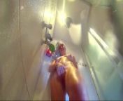 Voyeur camera in the shower. Young nude girl rubs her body with massage oil from young nude pussy